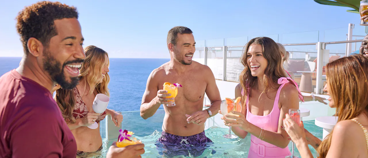 A group of adults enjoying a drink in the infinity pool