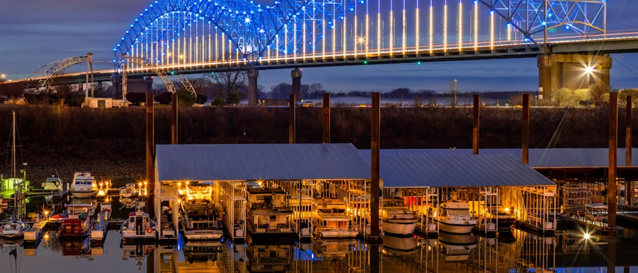 Hernando DeSoto Bridge over the Mississippi River that connects Memphis, Tennessee to West Memphis, Arkansas via Interstate 40 with the Harbor Landing pictured in the foreground.