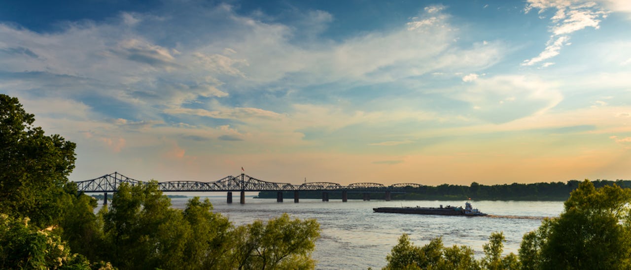 Boat in the Mississippi River near the Vicksburg Bridge in Vicksburg at sunset, Mississippi, USA