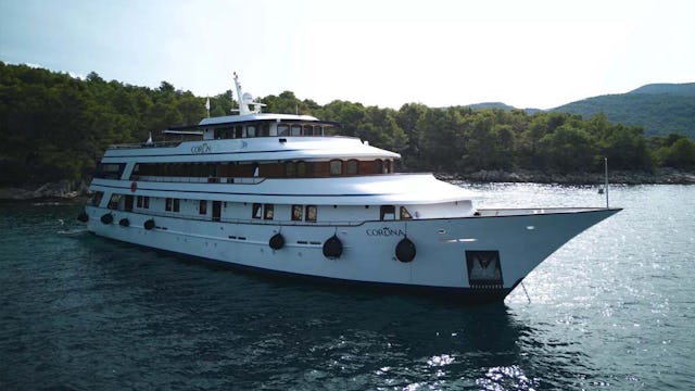 MV Corona sailing along a coast